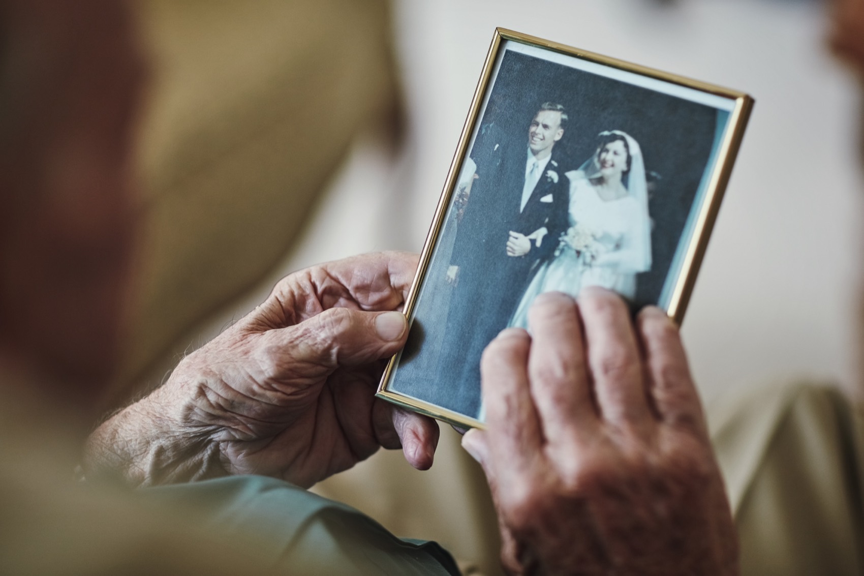 A senior viewing a vintage wedding-day photograph
